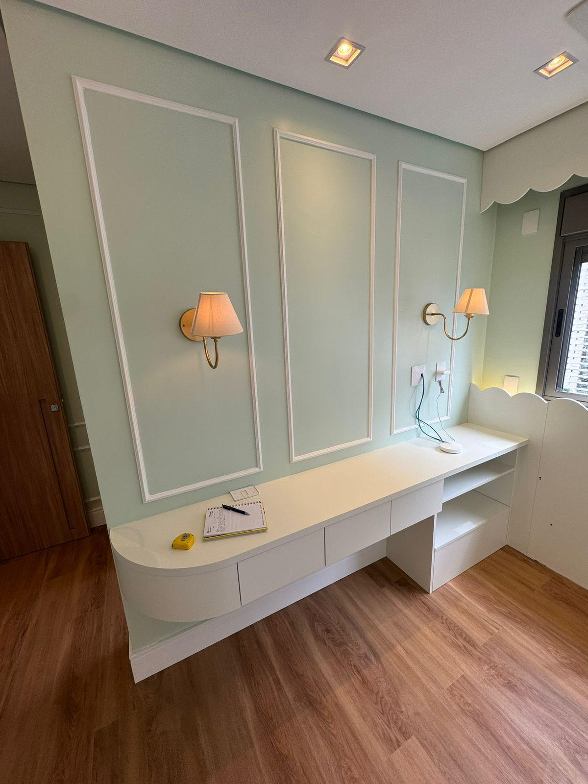 Home office sob medida com bancada laqueada branca e detalhes em boiserie